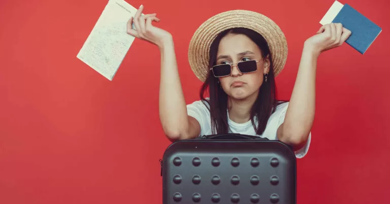 Anxious young lady with tickets and passport on red background