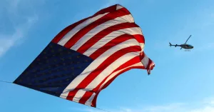U.S. flag with helicopter in background
