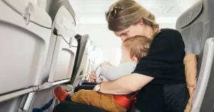Infant sitting in mother's lap on a plane