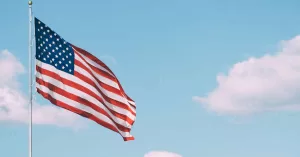 U.S. flag under white clouds during daytime